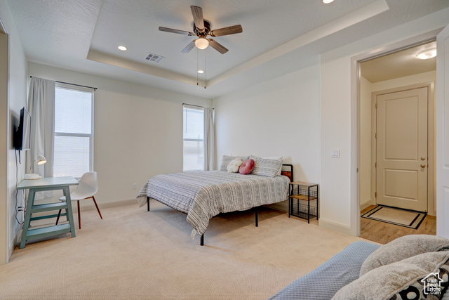 1329 Paseos Street Washington, UT 84780 - Photo 17 of 35 Bedroom featuring light colored carpet, a tray ceiling, recessed lighting, and ceiling fan