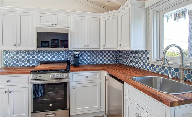 a kitchen with granite countertop a sink stove and cabinets