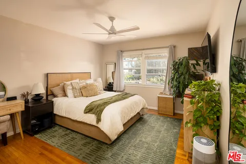 a bedroom with a bed potted plant with the window