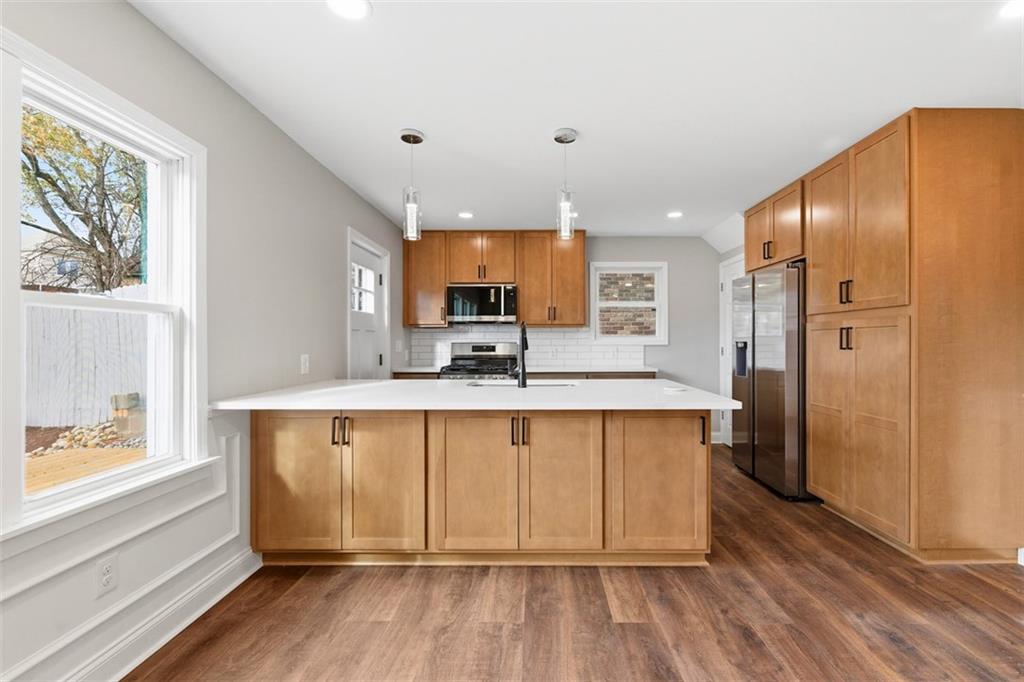 2214 Saranac Avenue Pittsburgh, PA 15216 - Photo 12 of 39 a large kitchen with stainless steel appliances a large window a oven and a refrigerator
