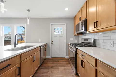 a kitchen with stainless steel appliances granite countertop a sink and cabinets