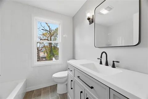 a bathroom with a sink vanity mirror and toilet
