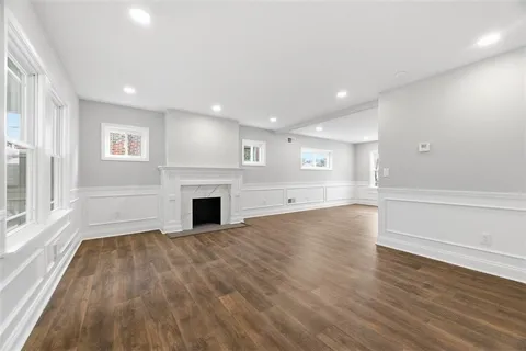 a view of a livingroom with wooden floor and a fireplace