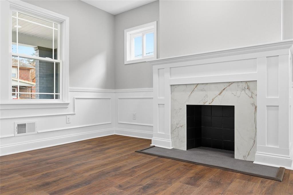2214 Saranac Avenue Pittsburgh, PA 15216 - Photo 8 of 39 an empty room with wooden floor fireplace and windows