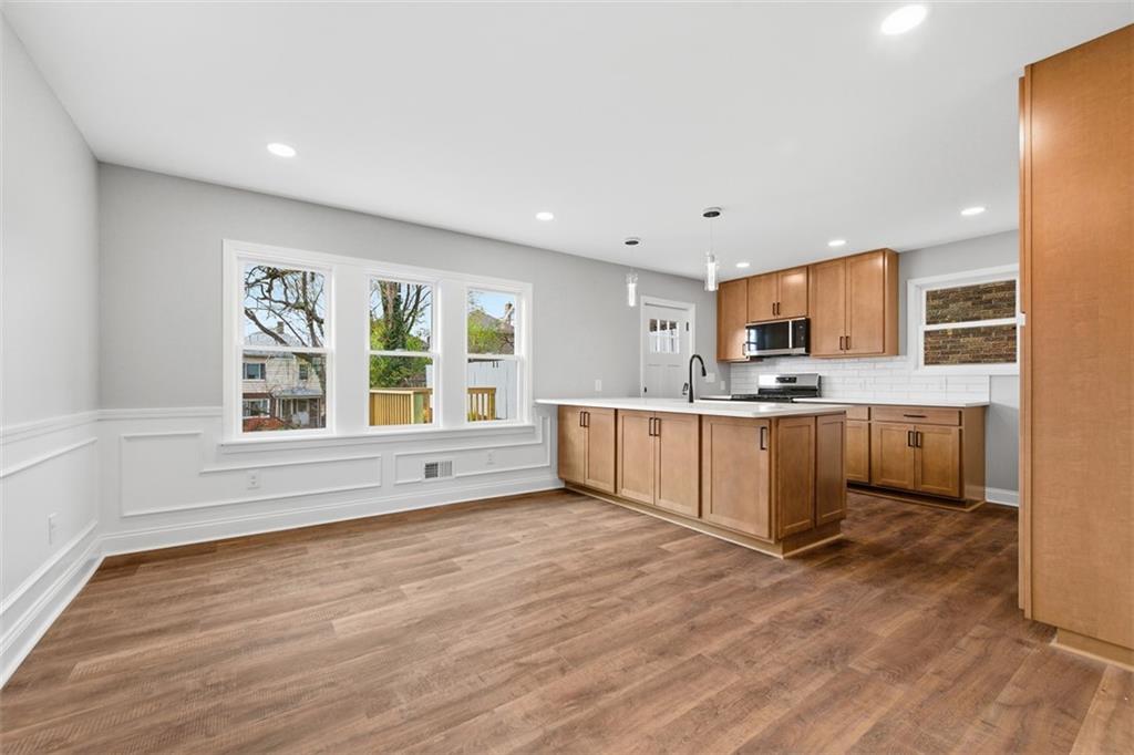 2214 Saranac Avenue Pittsburgh, PA 15216 - Photo 9 of 39 a large white kitchen with kitchen island granite countertop a stove top oven and a sink with granite countertops