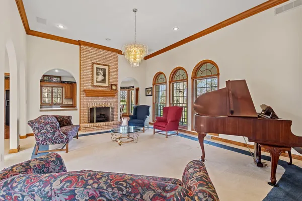a living room with furniture a fireplace and a chandelier