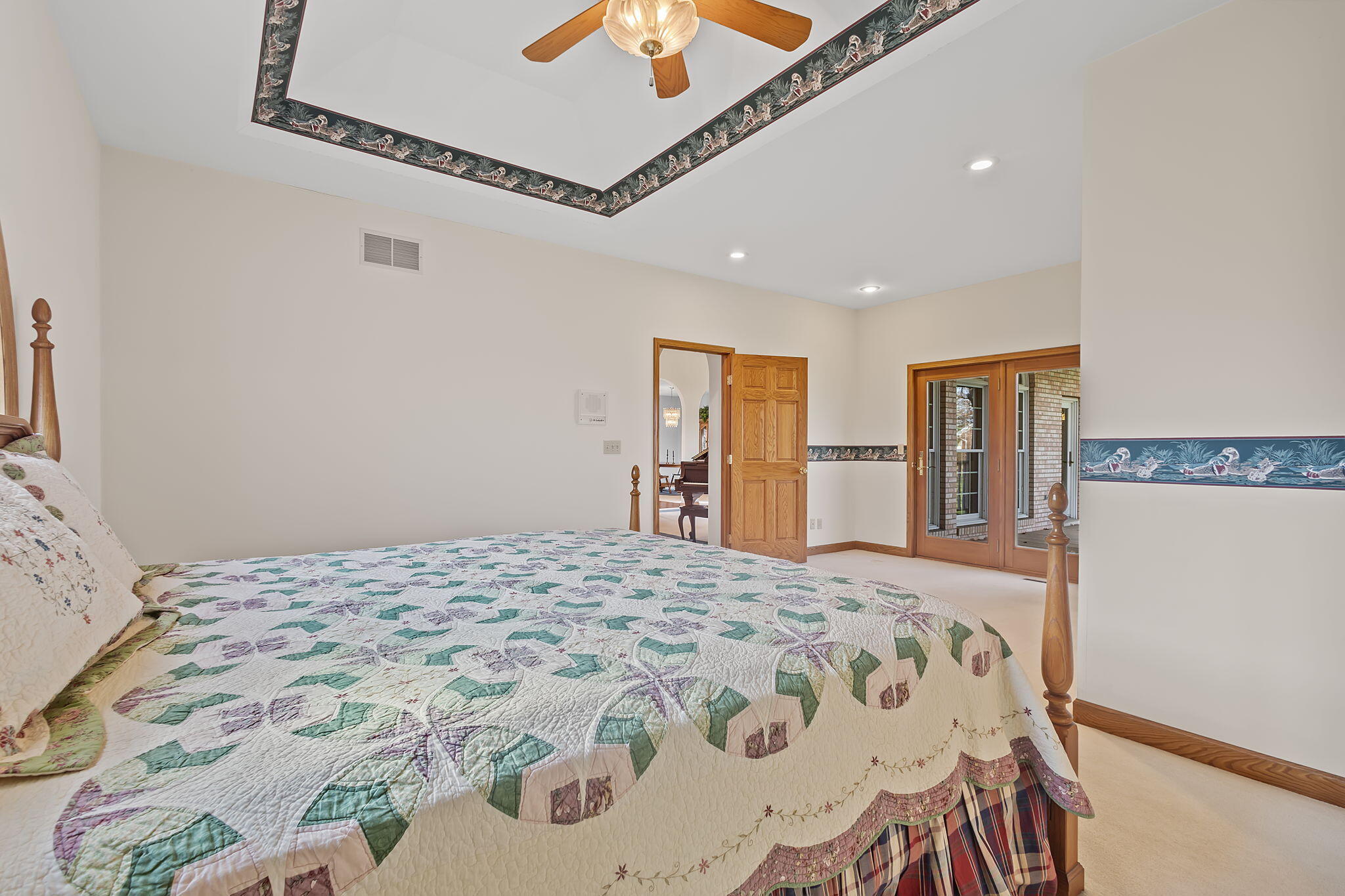 6664 Ridgeview Drive Demotte, IN 46310 - Photo 19 of 65 a bedroom with a large bed and a chandelier