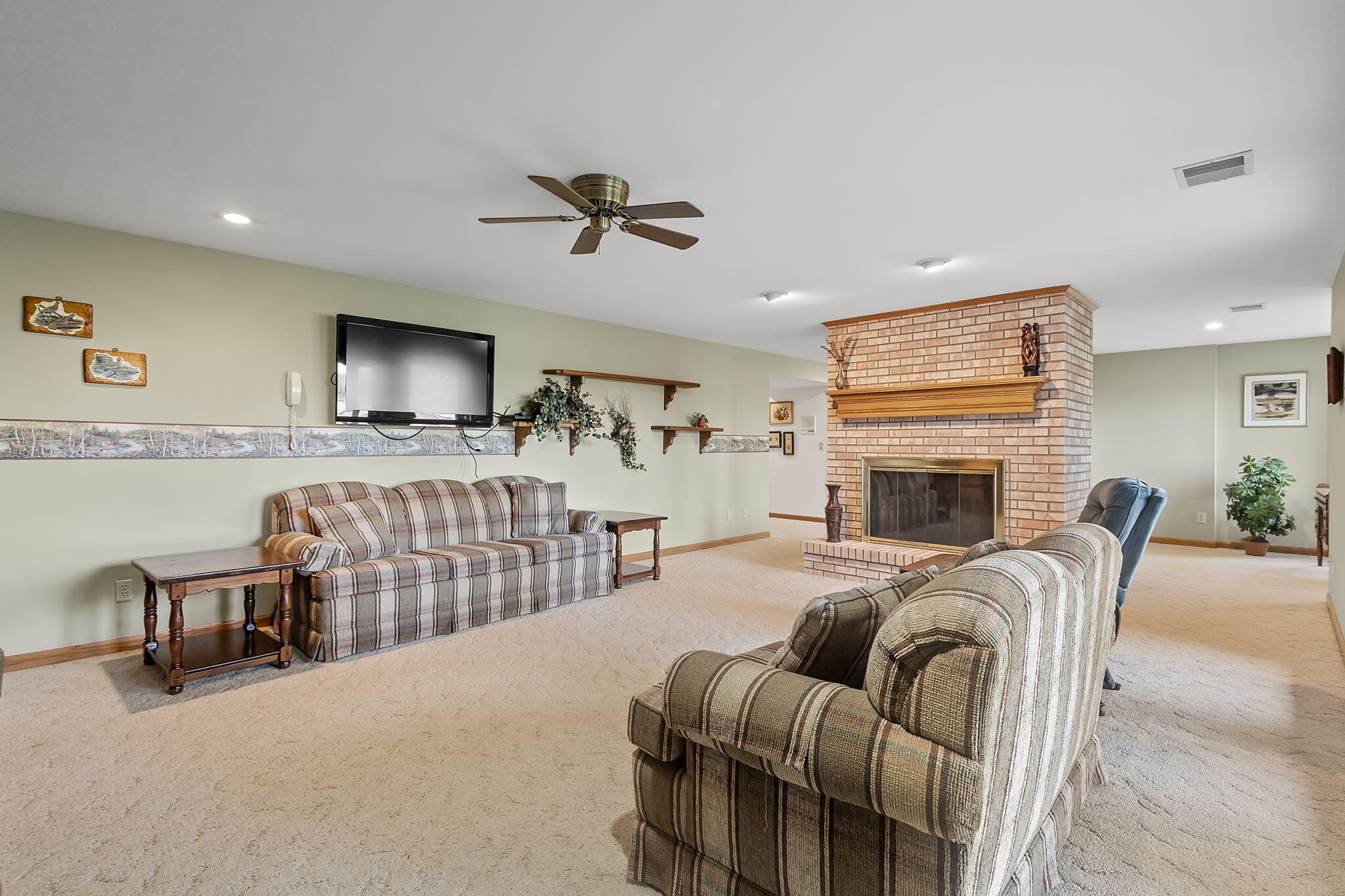 6664 Ridgeview Drive Demotte, IN 46310 - Photo 39 of 65 a living room with furniture a fireplace and a flat screen tv