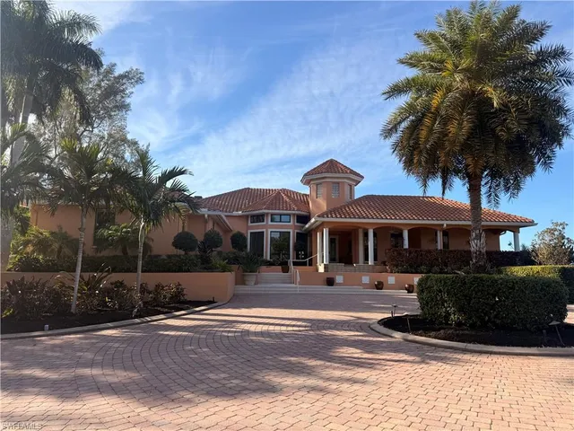 a front view of a house with a garden and trees