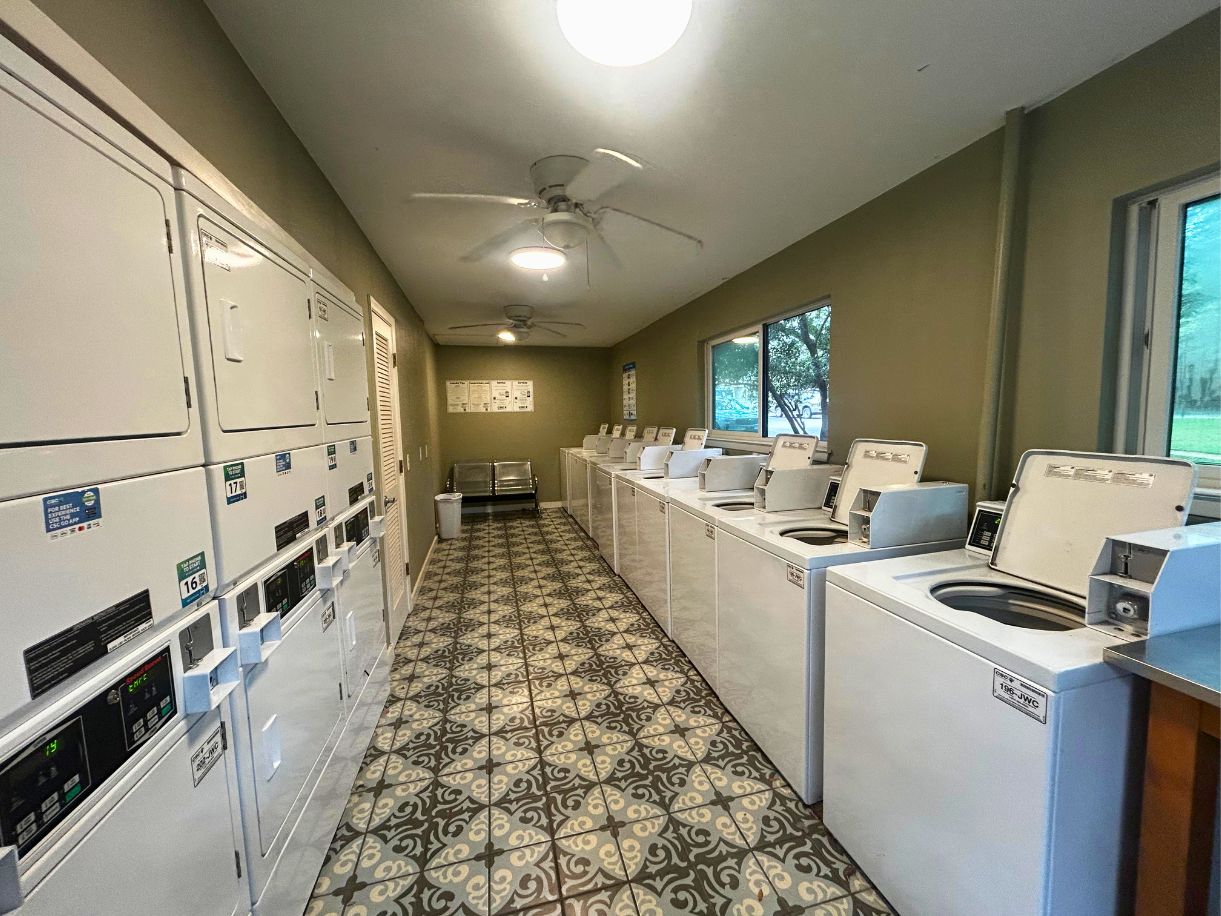 8210 Bent Tree Road, Unit 247 Austin, TX 78759 - Photo 19 of 21 Community laundry room featuring an array of white washers and dryers, patterned floor tiling, and ceiling fans
