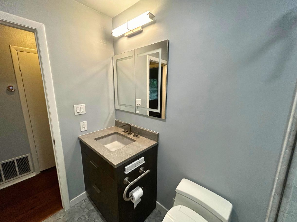 8210 Bent Tree Road, Unit 247 Austin, TX 78759 - Photo 6 of 21 Bathroom featuring a modern vanity with a rectangular sink and a dark countertop, illuminated by an overhead light fixture