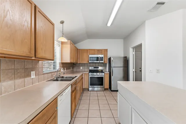 a kitchen with cabinets and stainless steel appliances