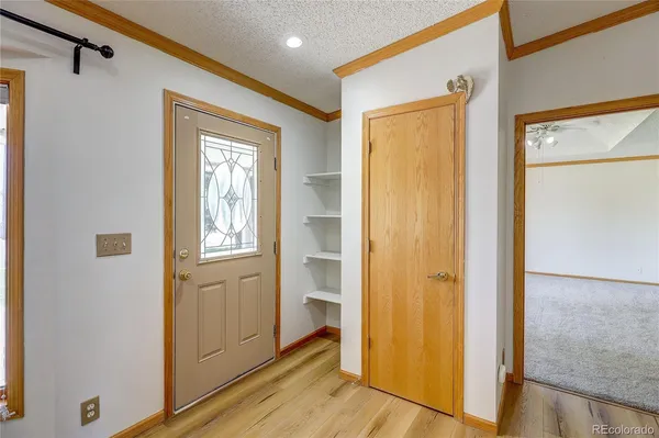 a view of a hallway with wooden floor and closet