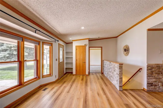 a view of a hallway with wooden floor and staircase