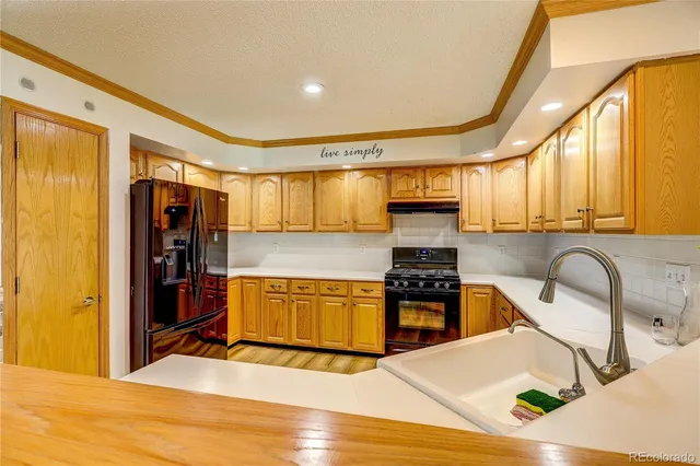 a kitchen with stainless steel appliances granite countertop a stove a sink and a refrigerator