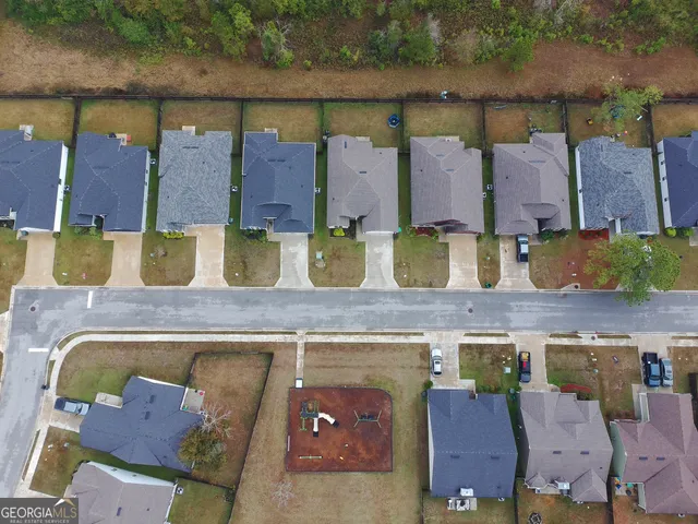 an aerial view of residential houses with outdoor space and lake view