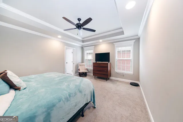 a spacious bedroom with a bed and a television