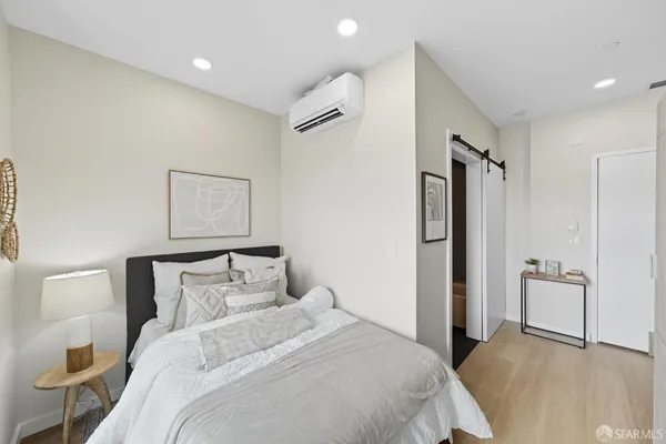 a bedroom with a bed and a refrigerator