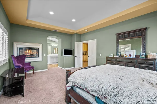 a spacious bedroom with a bed and a dresser