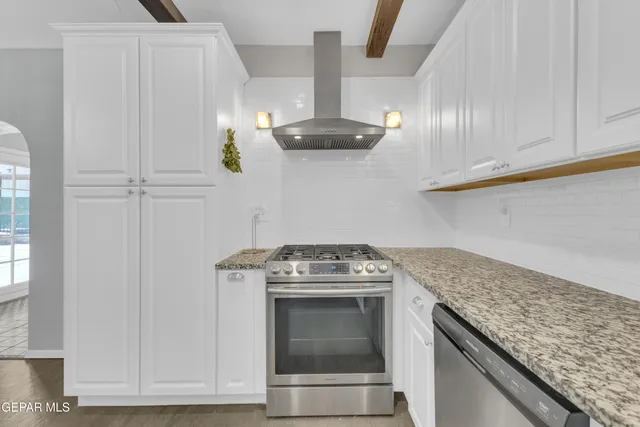 a kitchen with granite countertop a stove and a sink