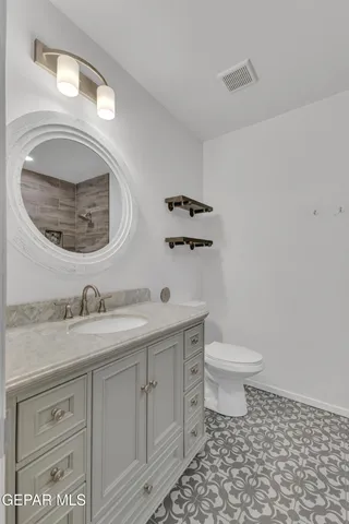 a bathroom with a sink a toilet and mirror