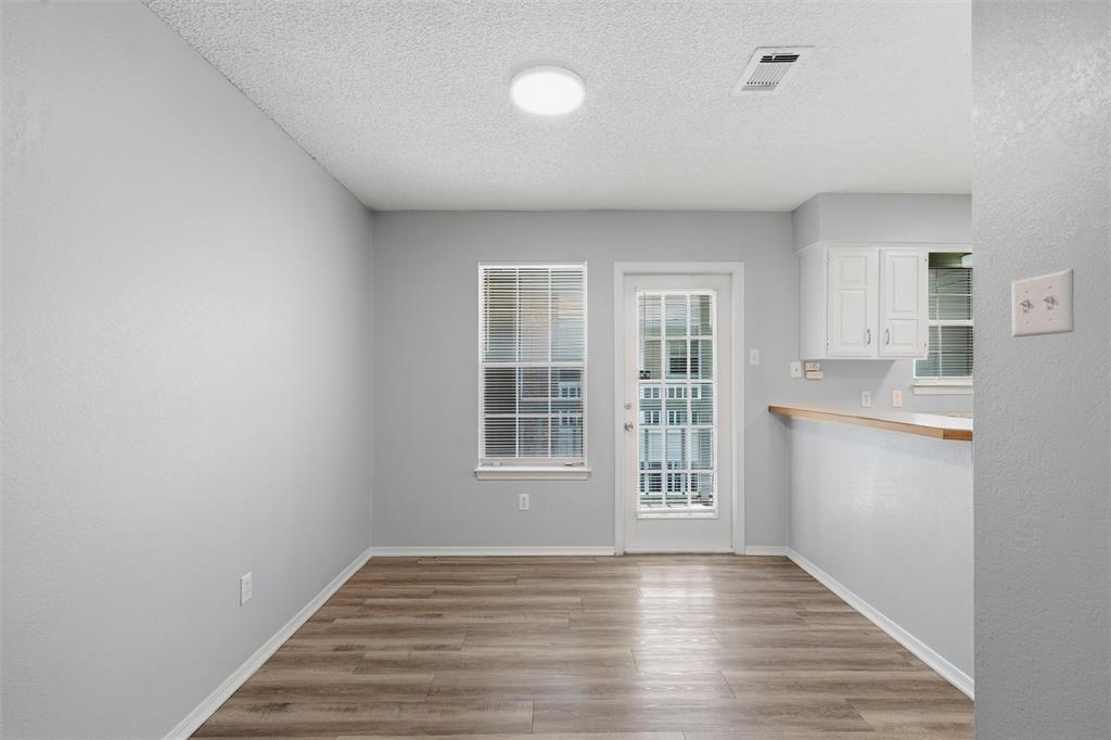 2332 Melissa Drive Waco, TX 76708 - Photo 5 of 15 Unfurnished dining area featuring light wood-type flooring and a textured ceiling