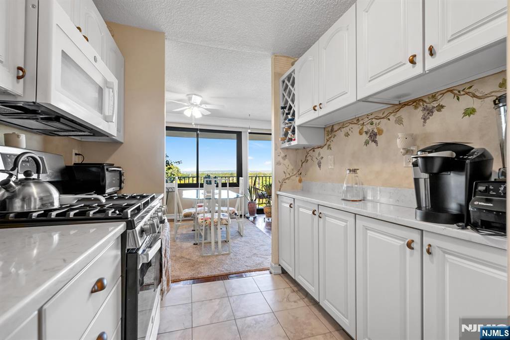 277 Prospect Avenue, Unit 10B Hackensack, NJ 07601 - Photo 17 of 34 a kitchen with sink a stove and cabinets