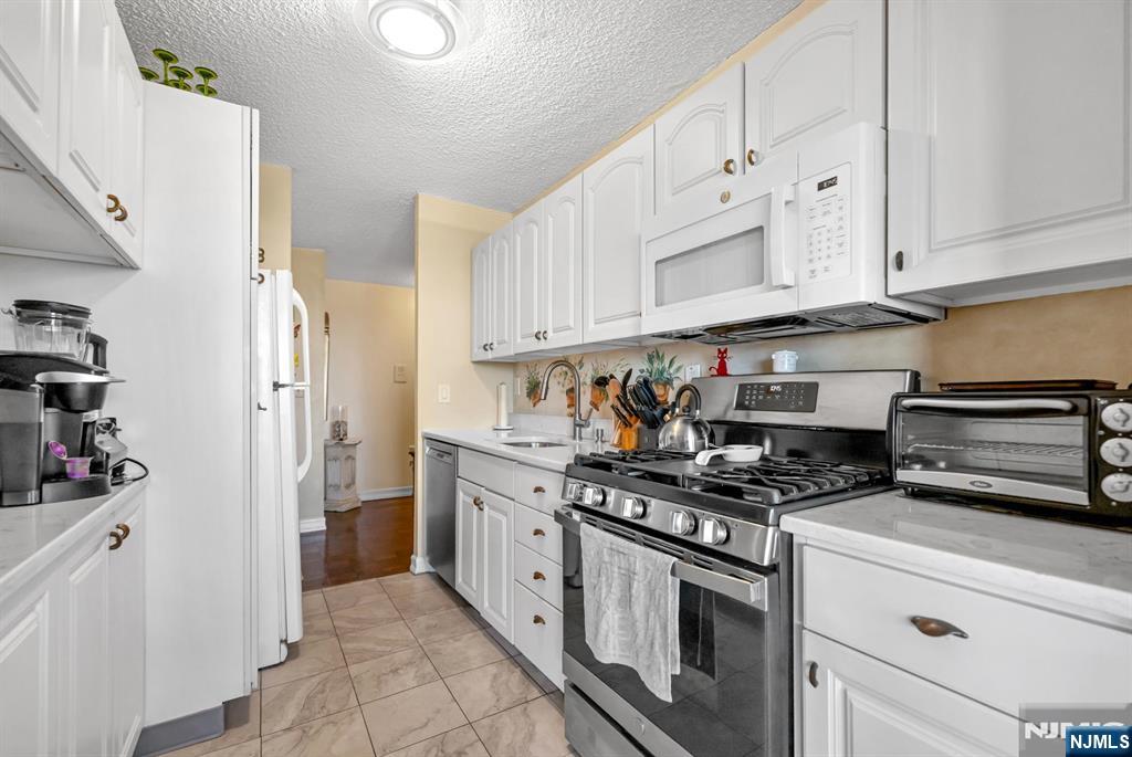 277 Prospect Avenue, Unit 10B Hackensack, NJ 07601 - Photo 19 of 34 a kitchen with stainless steel appliances granite countertop a stove and a refrigerator