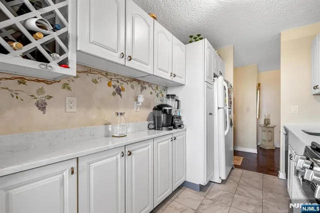 a kitchen with stainless steel appliances granite countertop a refrigerator and a stove