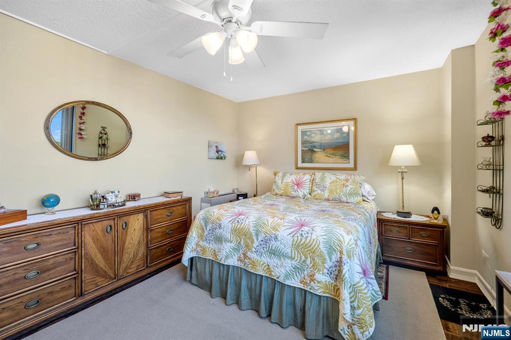 277 Prospect Avenue, Unit 10B Hackensack, NJ 07601 - Photo 4 of 34 a bedroom with bed and a chandelier