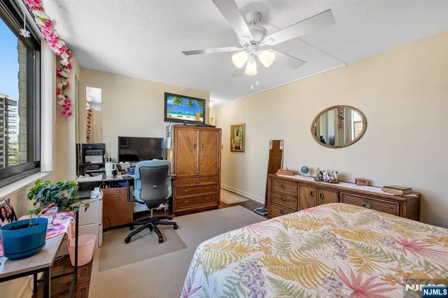 a bedroom with a bed a desk and chair with a mirror