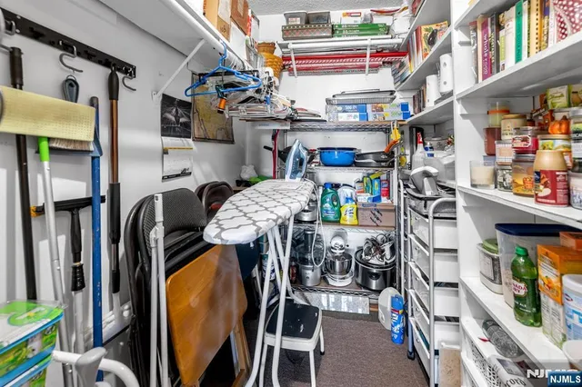 a utility room with stainless steel appliances and a wooden floor