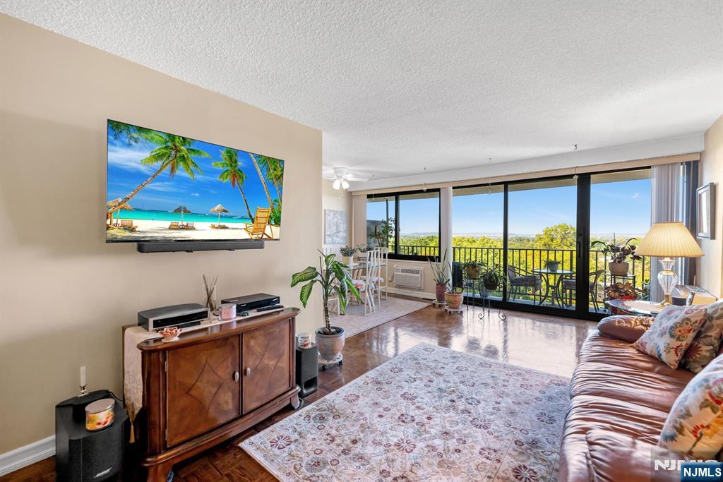 277 Prospect Avenue, Unit 10B Hackensack, NJ 07601 - Photo 10 of 34 a living room with furniture a rug floor to ceiling window and a flat screen tv