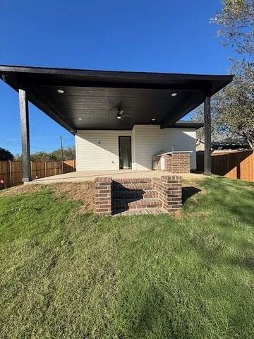 a backyard of a house with table and chairs