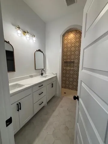 a bathroom with a double vanity sink and a mirror