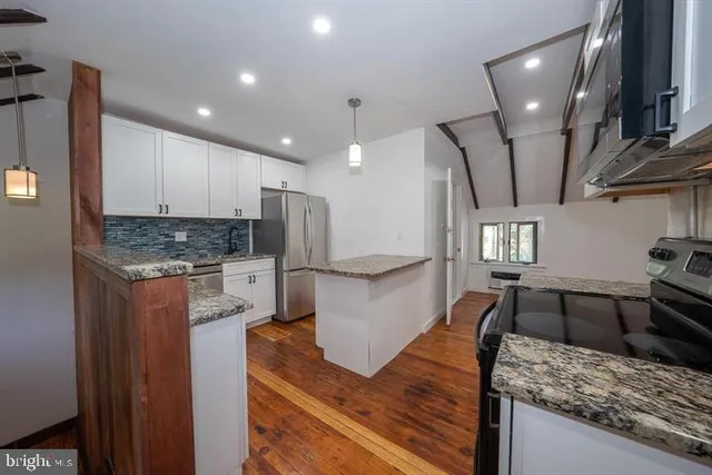 a kitchen with stainless steel appliances granite countertop a sink refrigerator and stove