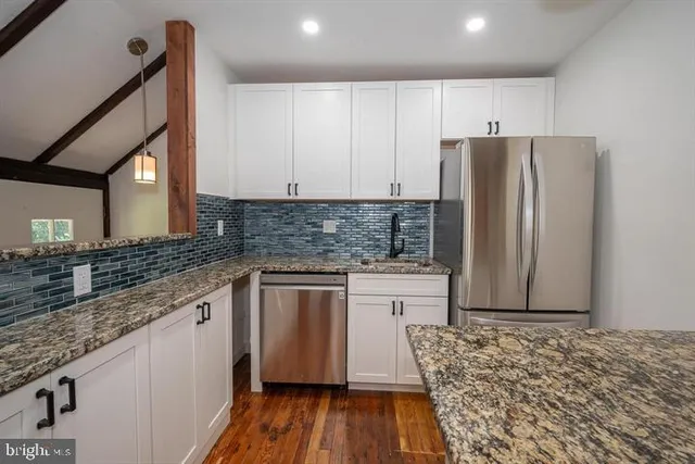 a kitchen with stainless steel appliances granite countertop a refrigerator sink and cabinets