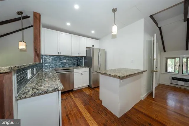 a kitchen with granite countertop a sink stainless steel appliances and cabinets