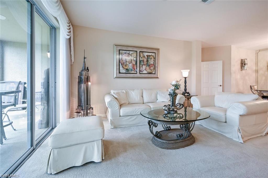 6065 Pinnacle Lane, Unit 1001 Naples, FL 34110 - Photo 12 of 26 a living room with furniture and a large window