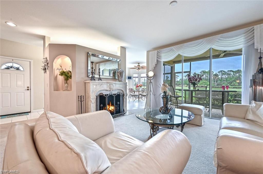 6065 Pinnacle Lane, Unit 1001 Naples, FL 34110 - Photo 14 of 26 a living room with furniture large window and fireplace