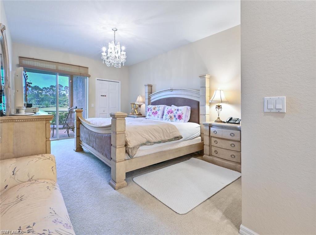 6065 Pinnacle Lane, Unit 1001 Naples, FL 34110 - Photo 17 of 26 a bedroom with a bed chandelier and window