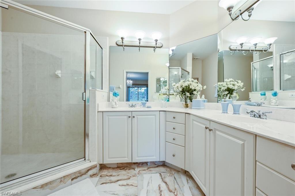 6065 Pinnacle Lane, Unit 1001 Naples, FL 34110 - Photo 19 of 26 a spacious bathroom with a shower sink and mirror