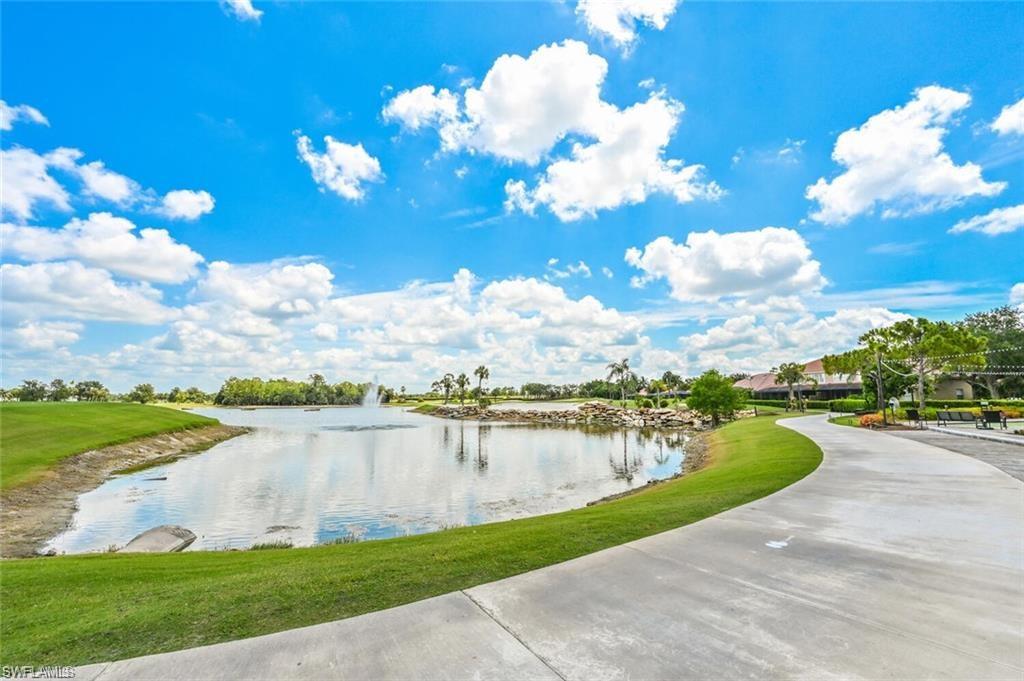 6065 Pinnacle Lane, Unit 1001 Naples, FL 34110 - Photo 2 of 26 a view of a lake with houses in the back
