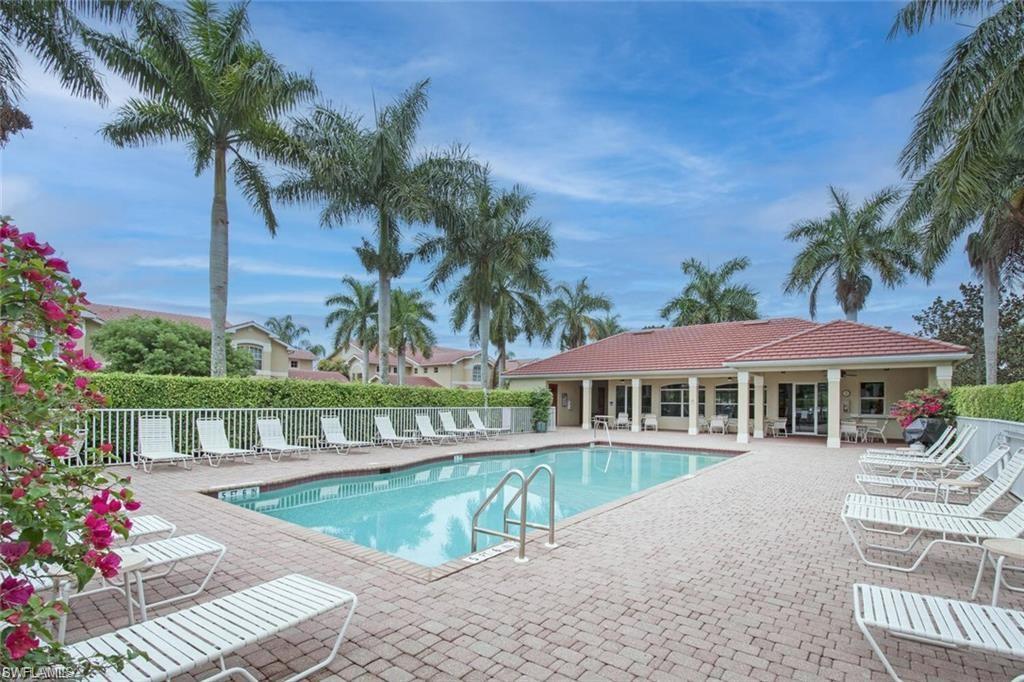 6065 Pinnacle Lane, Unit 1001 Naples, FL 34110 - Photo 22 of 26 a view of a house with a yard and swimming pool