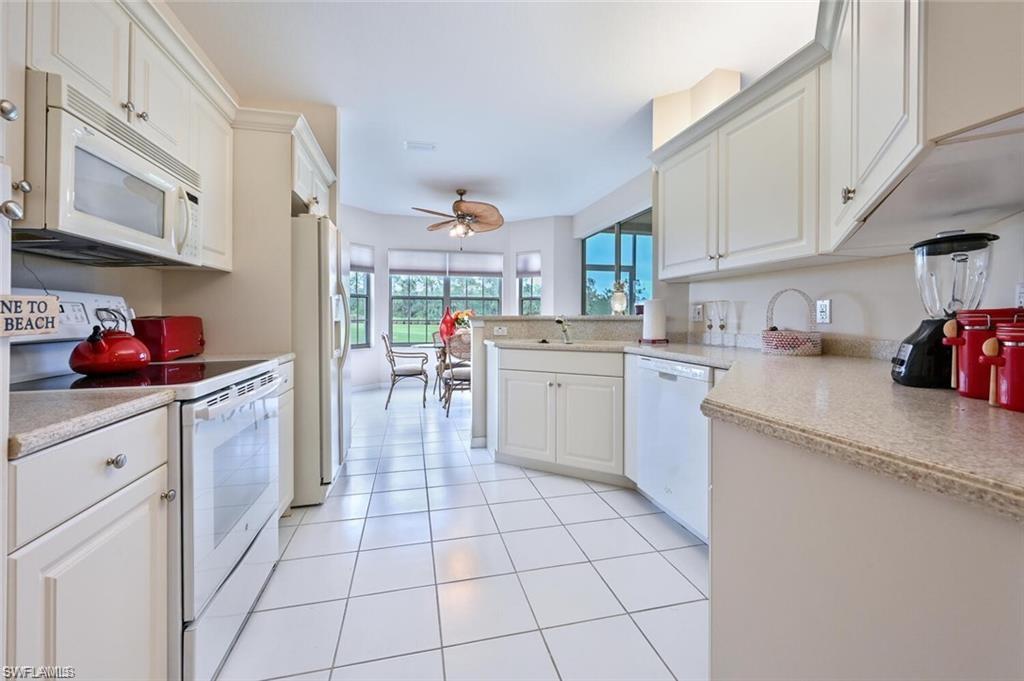 6065 Pinnacle Lane, Unit 1001 Naples, FL 34110 - Photo 6 of 26 a kitchen with a sink a stove and cabinets
