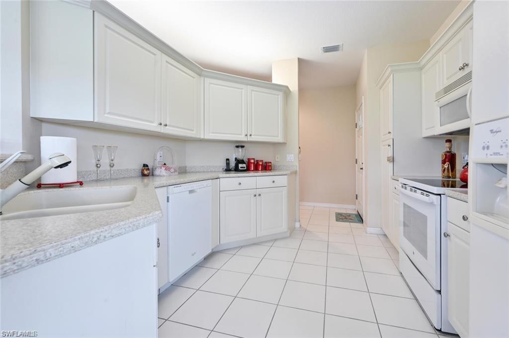 6065 Pinnacle Lane, Unit 1001 Naples, FL 34110 - Photo 7 of 26 a kitchen with cabinets and window