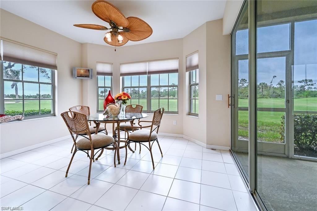 6065 Pinnacle Lane, Unit 1001 Naples, FL 34110 - Photo 10 of 26 a dining room with furniture a chandelier and large window