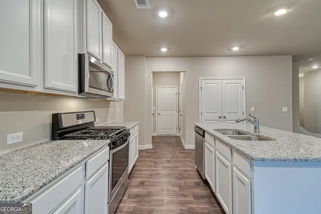 a view of kitchen with kitchen island microwave and wooden floor