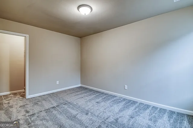 an empty room with closet and a hallway