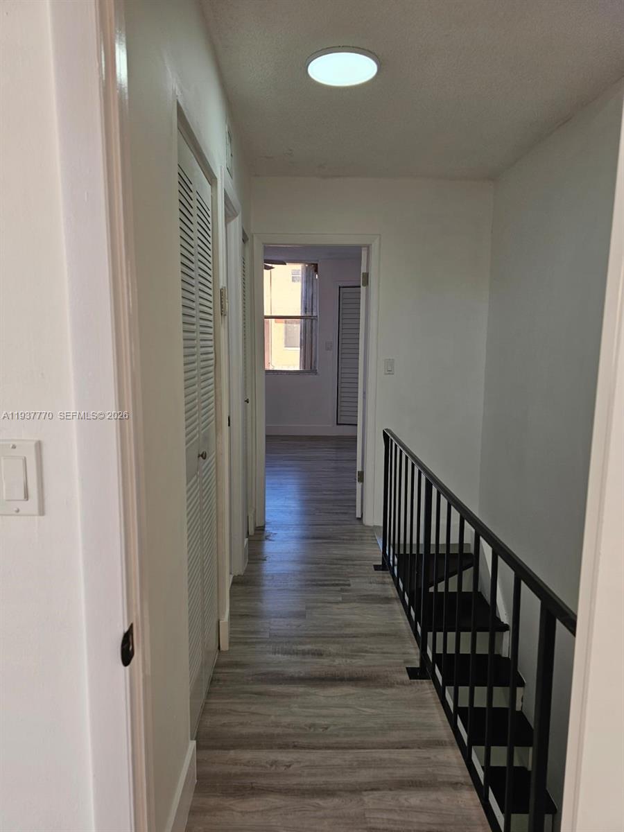 4357 West 11th Lane, Unit 55 Hialeah, FL 33012 - Photo 11 of 17 a view of a hallway with wooden floor and staircase
